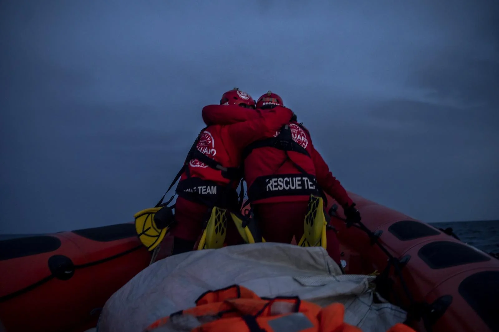 Rescuers of the Spanish NGO Open Arms, Alberto Agrelo and Alejandro Samper embrace in a gesture of encouragement as they go to a possible target, Saturday,Feb.6,2021