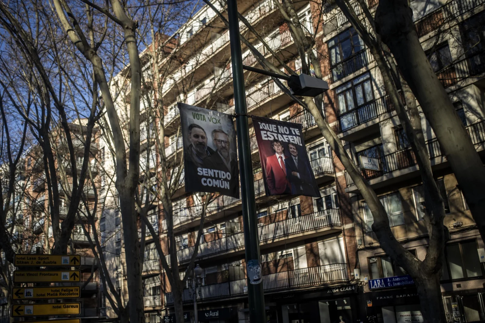 An electoral poster for Vox is displayed next to another