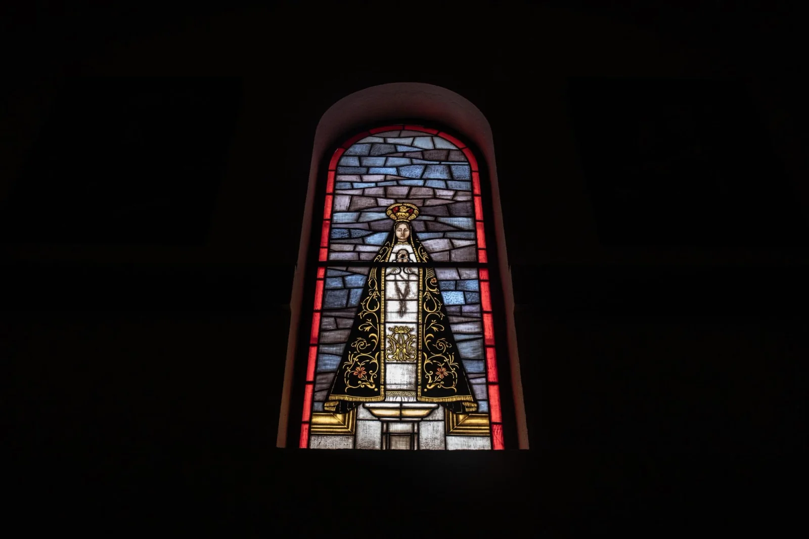 A stained-glass window depicting the Virgin of Solitude