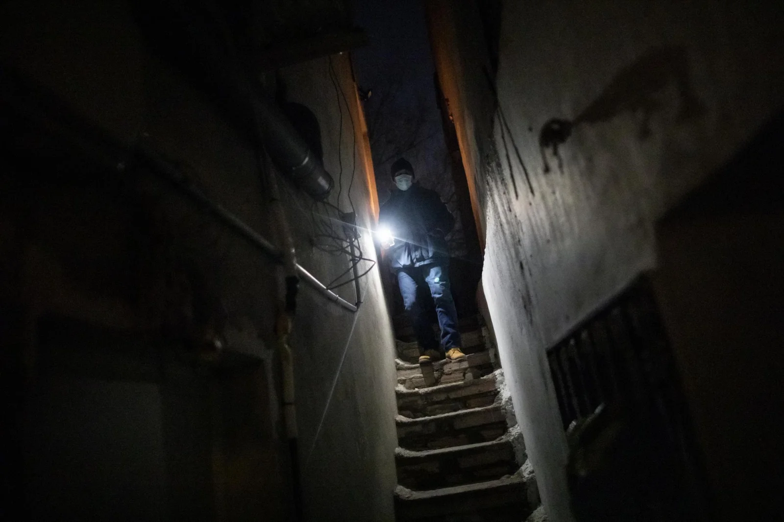 Omar baja las escaleras hacia su casa en el Sector V con el móvil encendido para poder iluminarse
