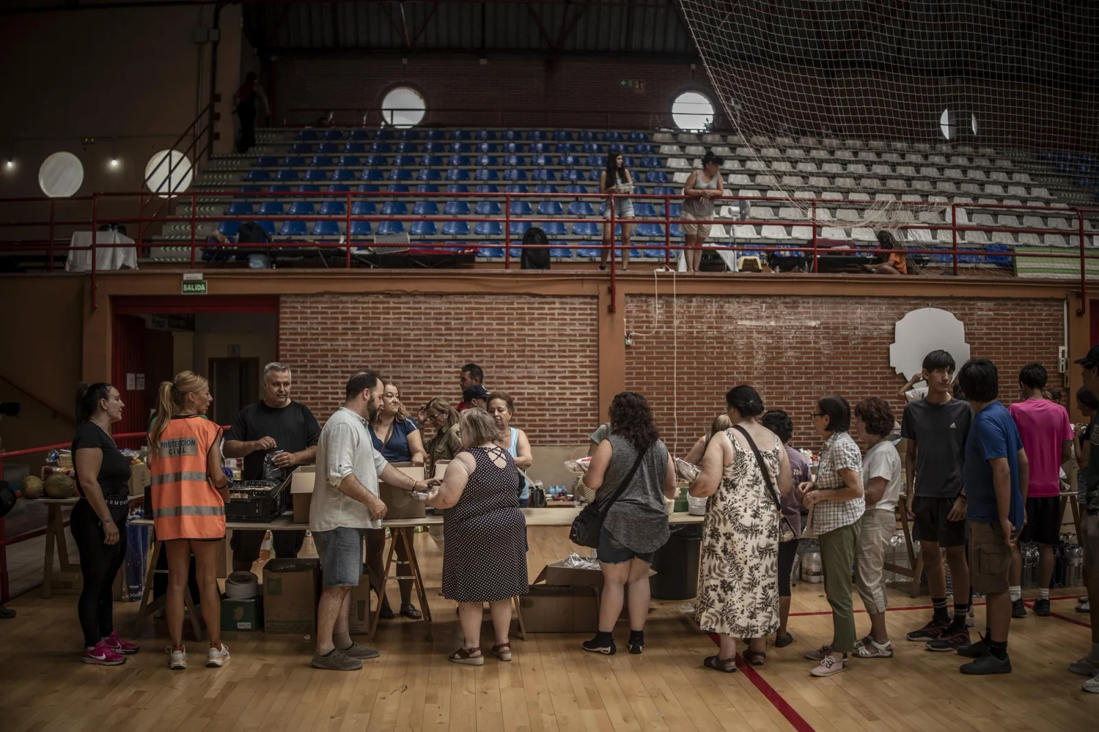 Displaced people from the Tiétar Valley area queue up to