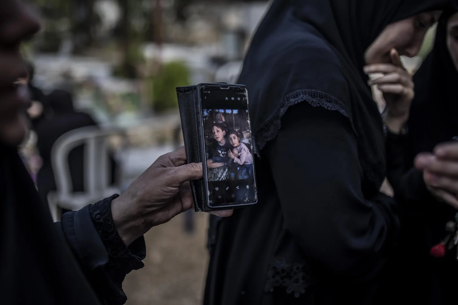 A woman shows with her phone two victims of the attack,