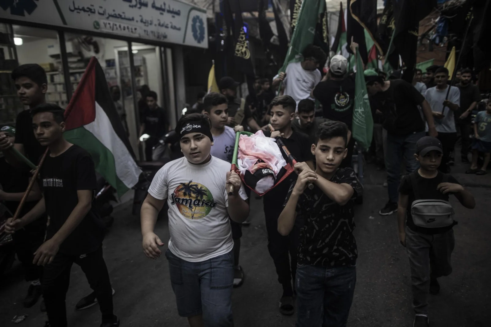 Cientos de palestinos recrean un funeral en el campo de refugiados de Bourj el-Barajneh en Beirut durante una protesta por los bombardeos de Israel sobre la población de Gaza