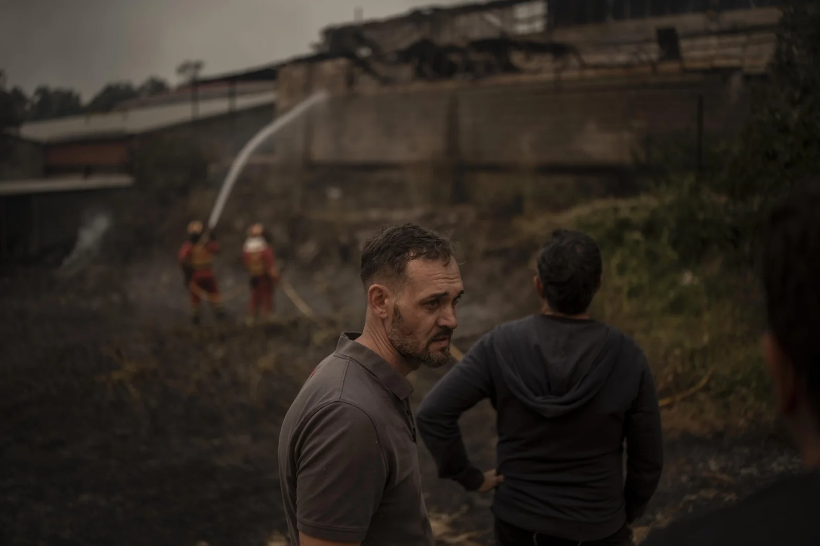 A local resident watches the firefighting efforts at his
