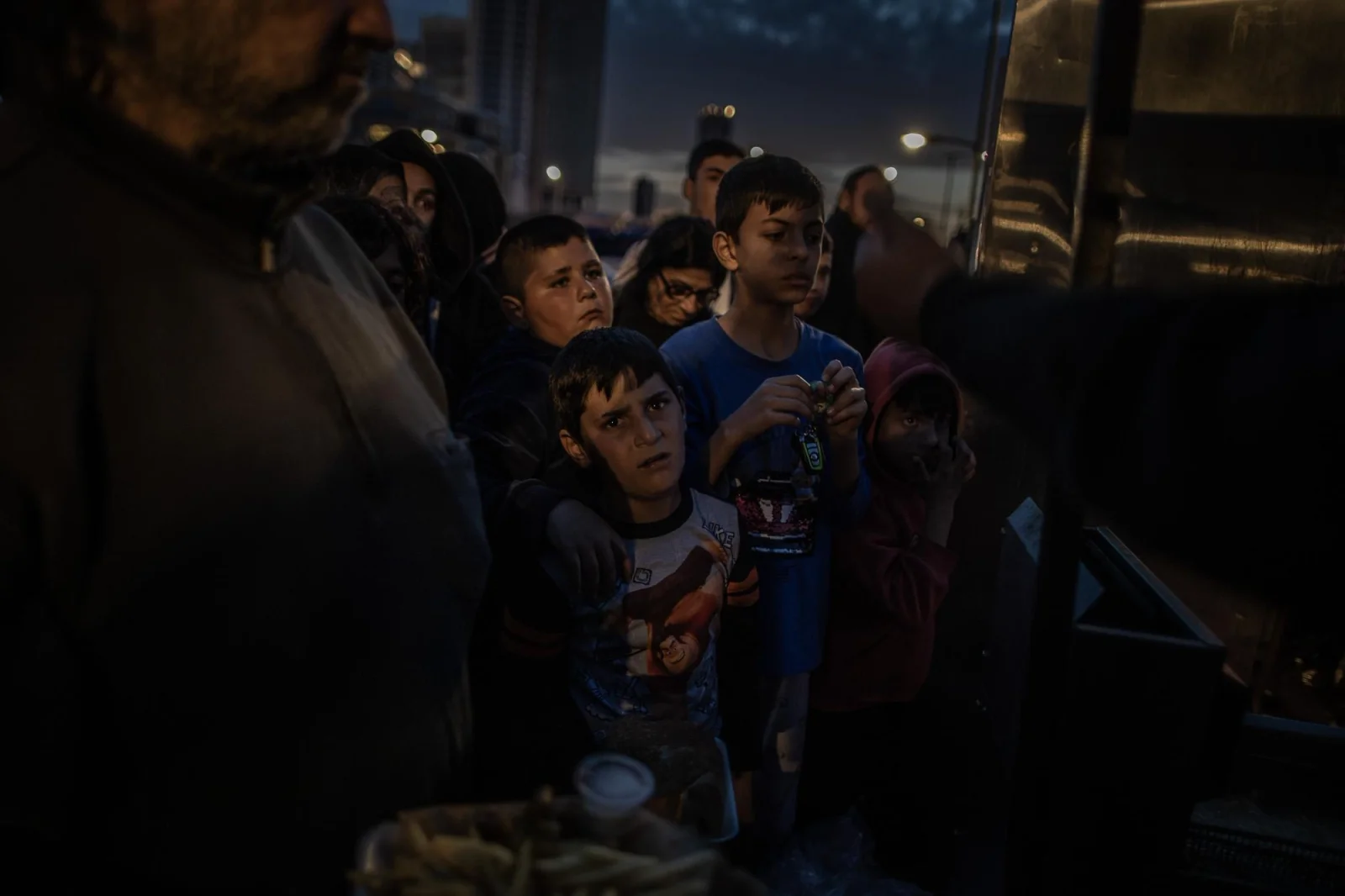 Un grupo de niños desplazados de su hogar por los recientes ataques israelíes esperan recibir una ración de comida en la ciudad de Beirut . Líbano