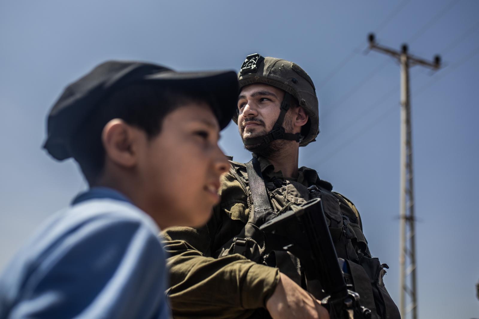 Un niño palestino frente a un soldado israelí durante una protesta en el pueblo de Beit Dejan contra la expansión de los asentamientos de los colonos.