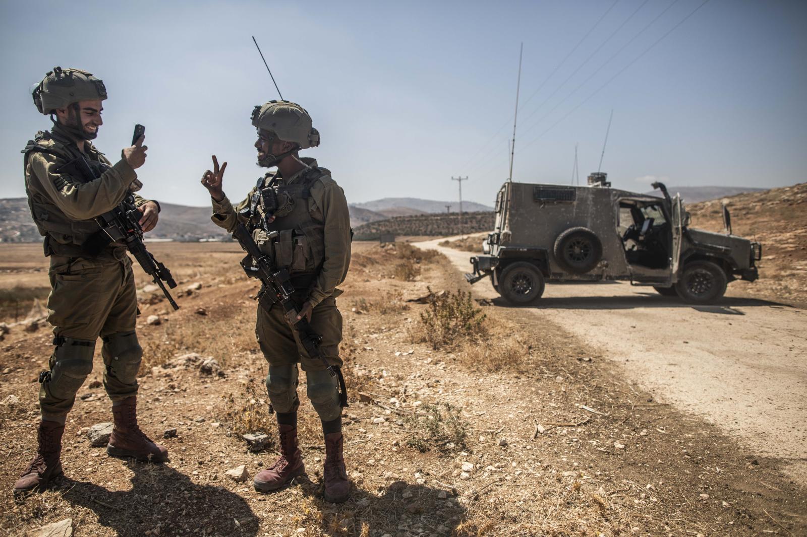 Dos soldados del ejército israeli se hacen fotos entre risas durante una protesta en el pueblo de Beit Dejan.