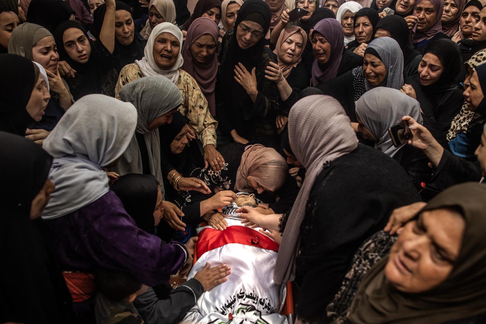 La madre de Ezzedine Kanaan, de 21 años, abraza el cuerpo de su hijo, que murió de un disparo en la cabeza durante la incursión del ejército israelí en el campo de refugiados de Jenín.